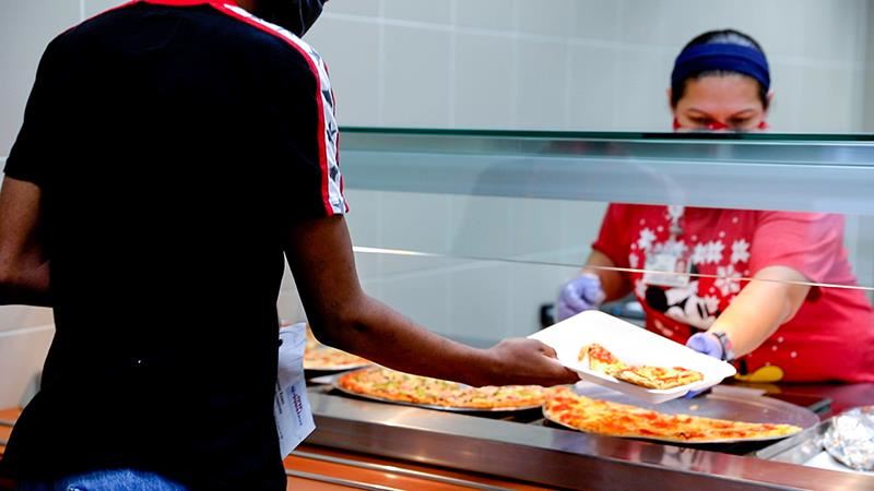 A Cypress Lakes High School student is served a slice of pizza during lunch. 